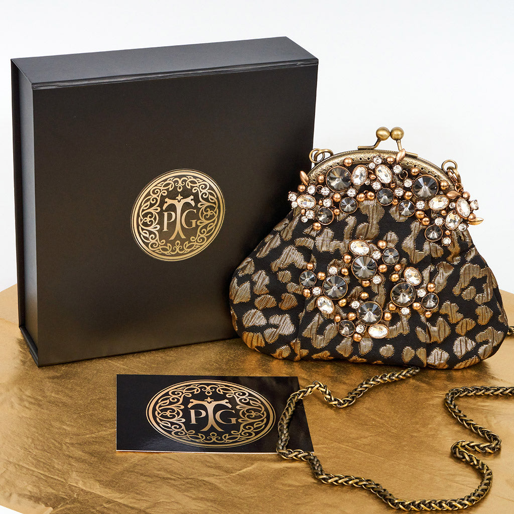 Meet Celeste. A black and gold evening bag with rhinestone embellishments.