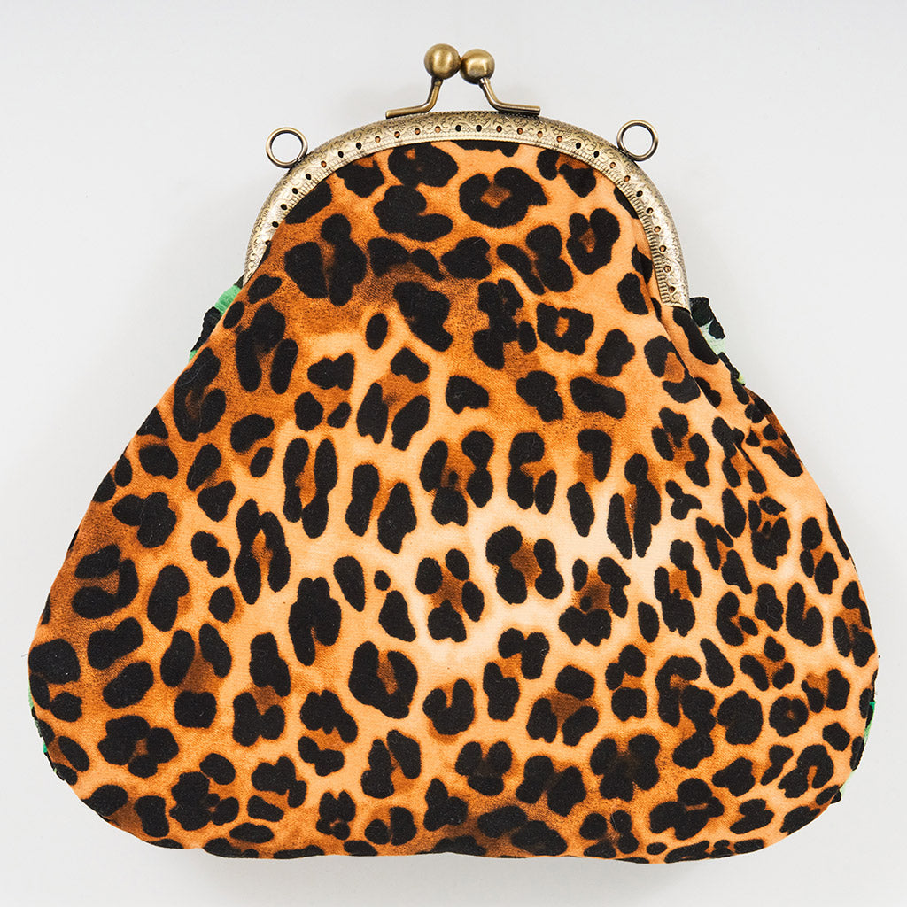 Meet Tabatha. A leopard print and green textile handbag with bronze rhinestones.