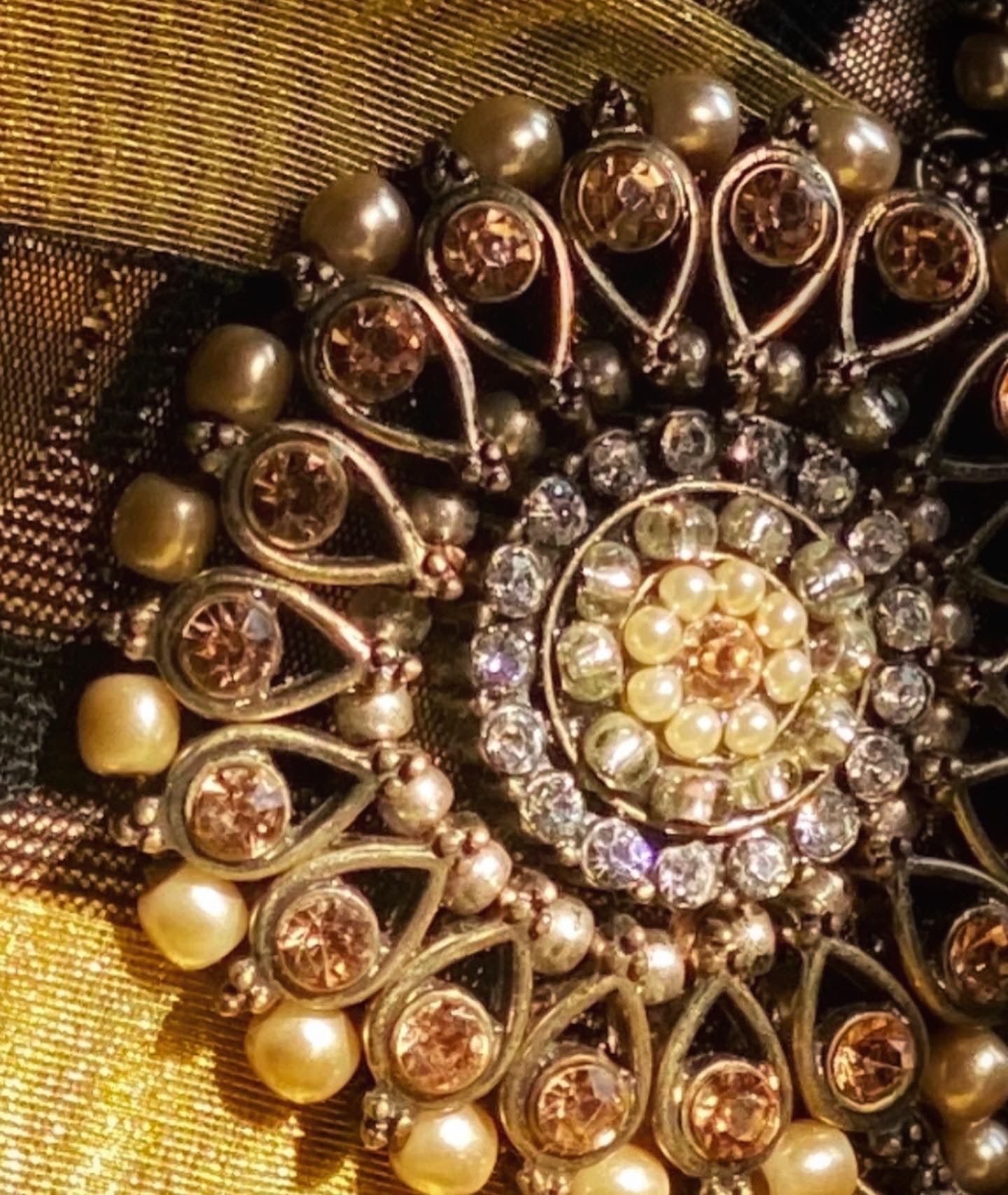 Meet Olympia. A gold, brown and black handbag with circular pearl motifs.