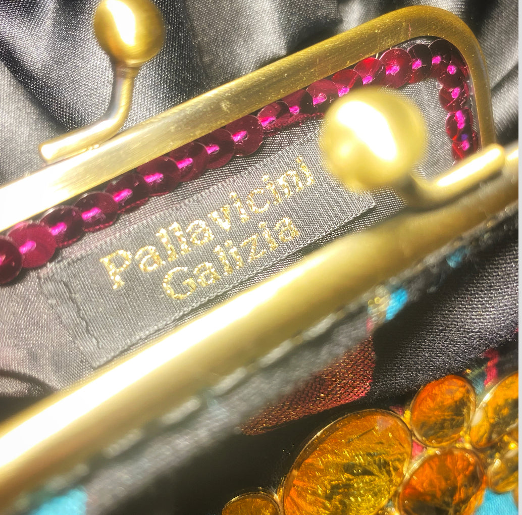 Meet Brigitte. A wristlet purse of black, blue and pink flowers, with a garland of gold rhinestones.