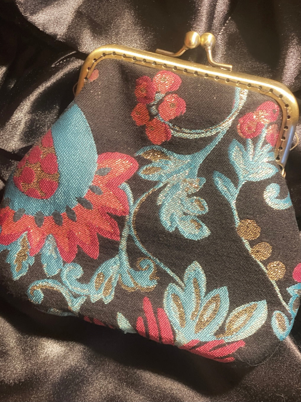 Meet Brigitte. A wristlet purse of black, blue and pink flowers, with a garland of gold rhinestones.