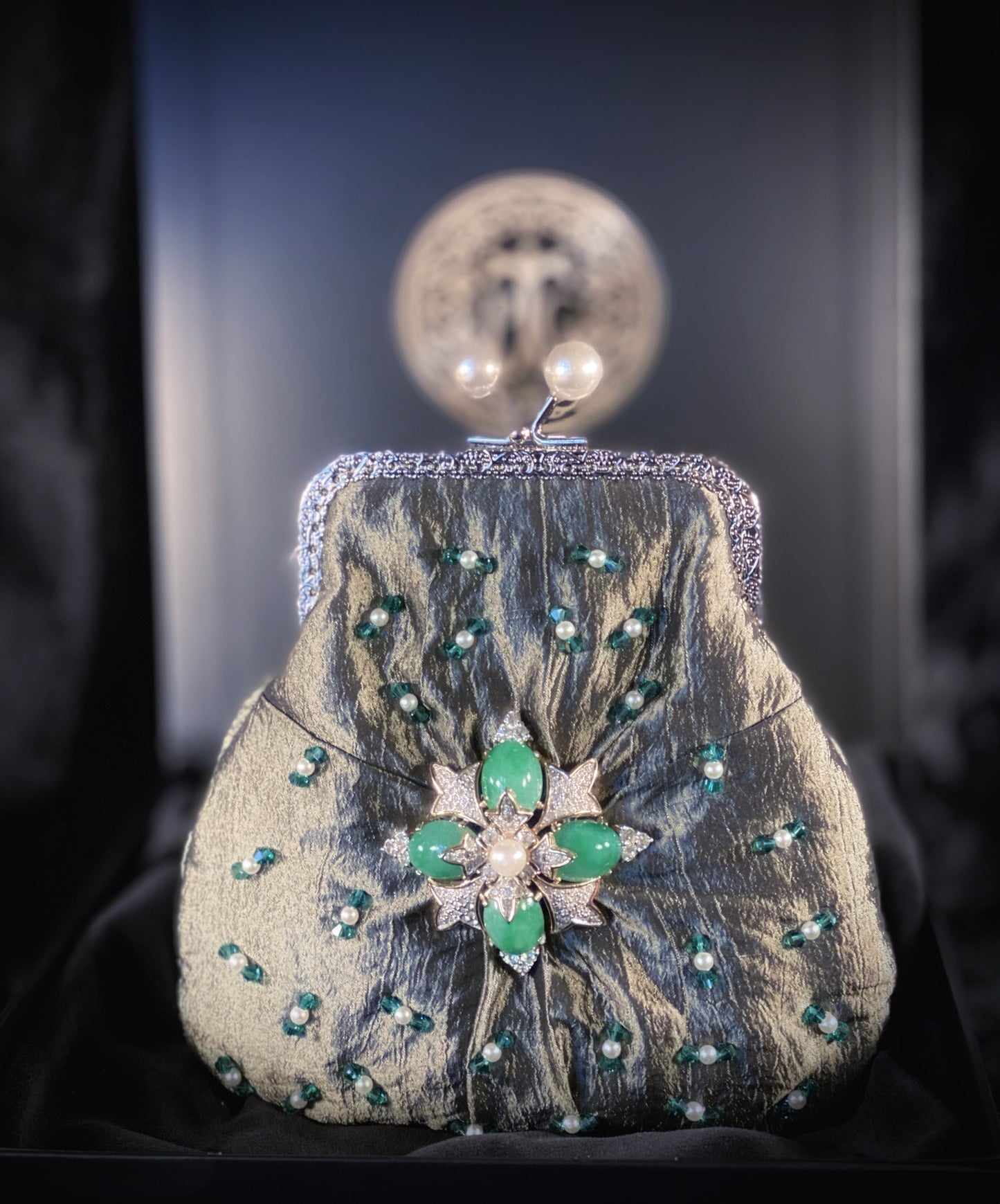 Meet Fern. A green, silk wristlet purse with faux pearl clasp and an antique green stone centrepiece.