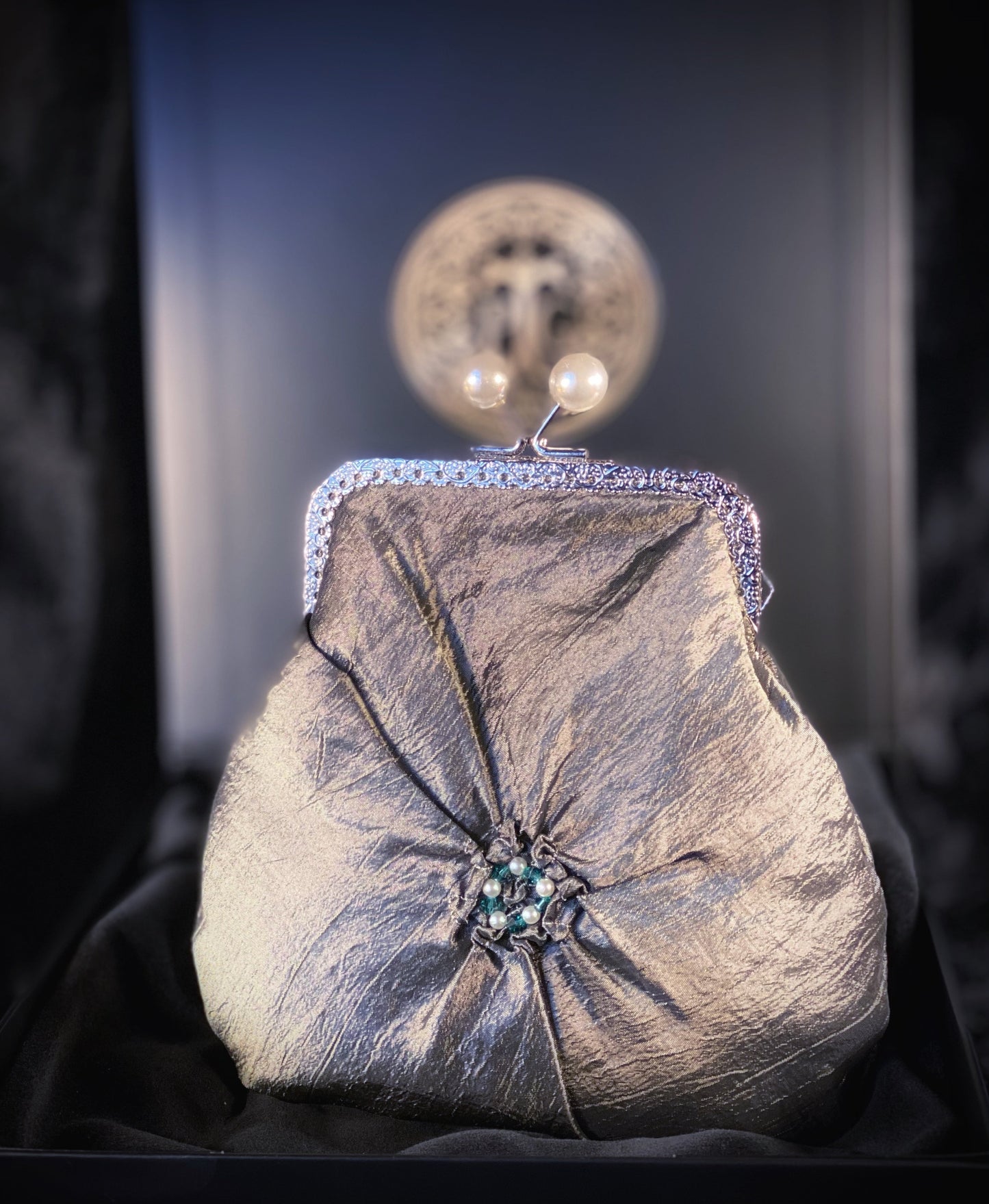 Meet Fern. A green, silk wristlet purse with faux pearl clasp and an antique green stone centrepiece.