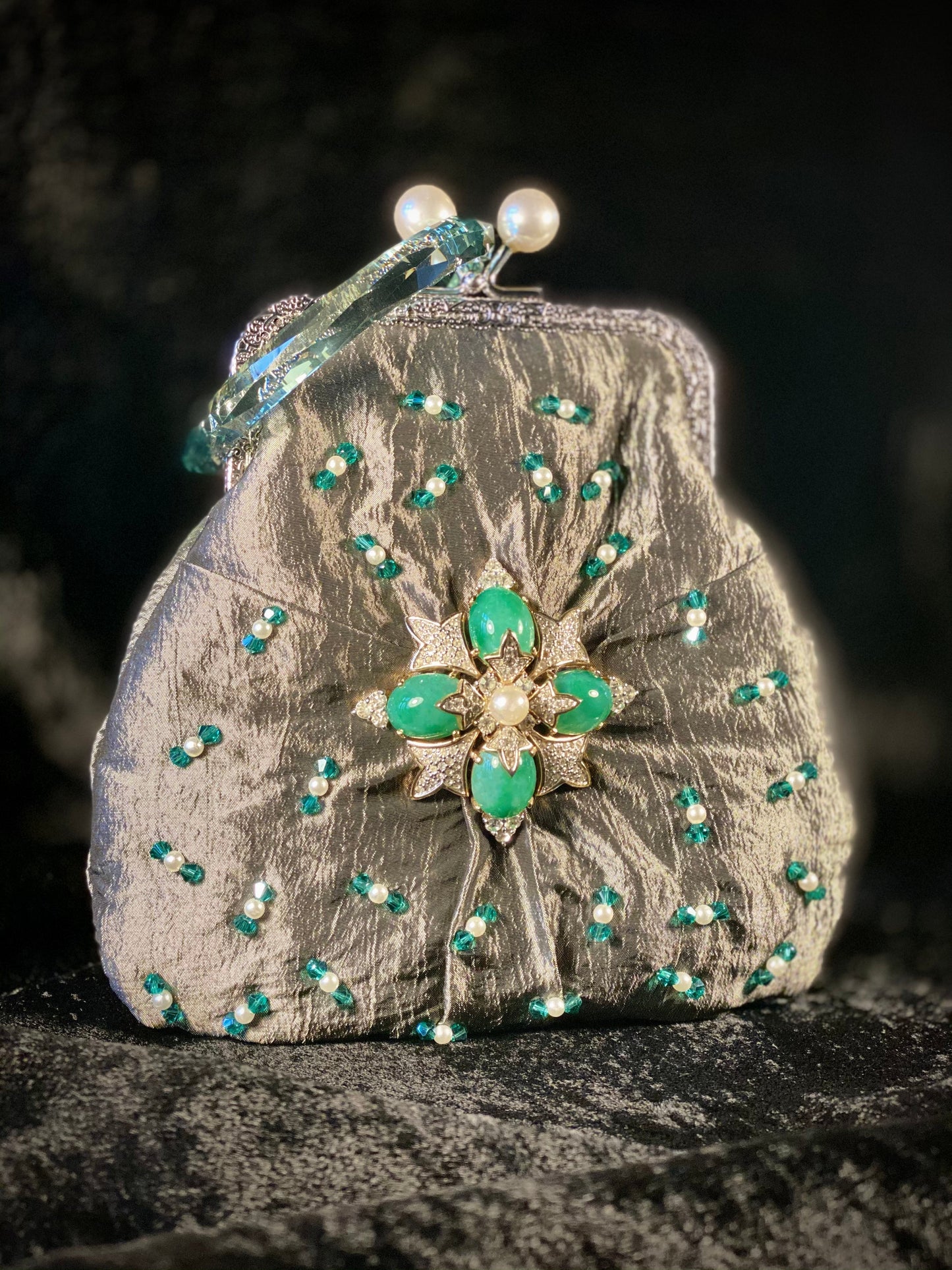 Meet Fern. A green, silk wristlet purse with faux pearl clasp and an antique green stone centrepiece.