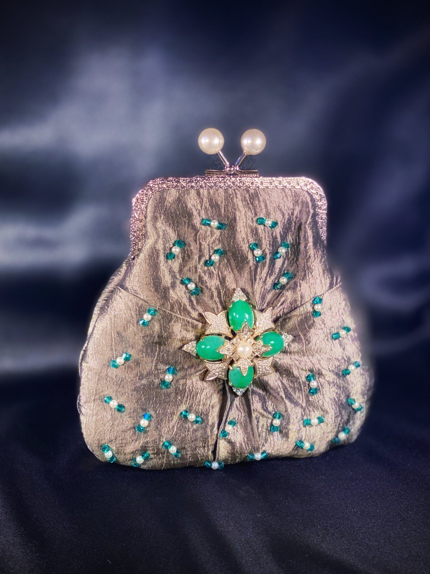 Meet Fern. A green, silk wristlet purse with faux pearl clasp and an antique green stone centrepiece.