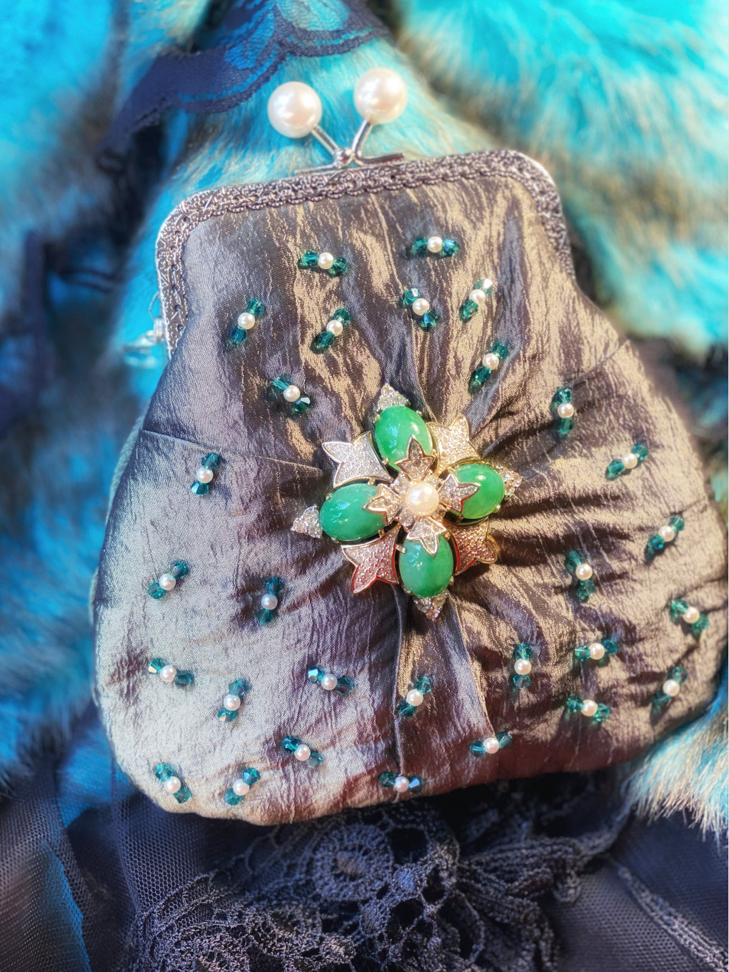 Meet Fern. A green, silk wristlet purse with faux pearl clasp and an antique green stone centrepiece.