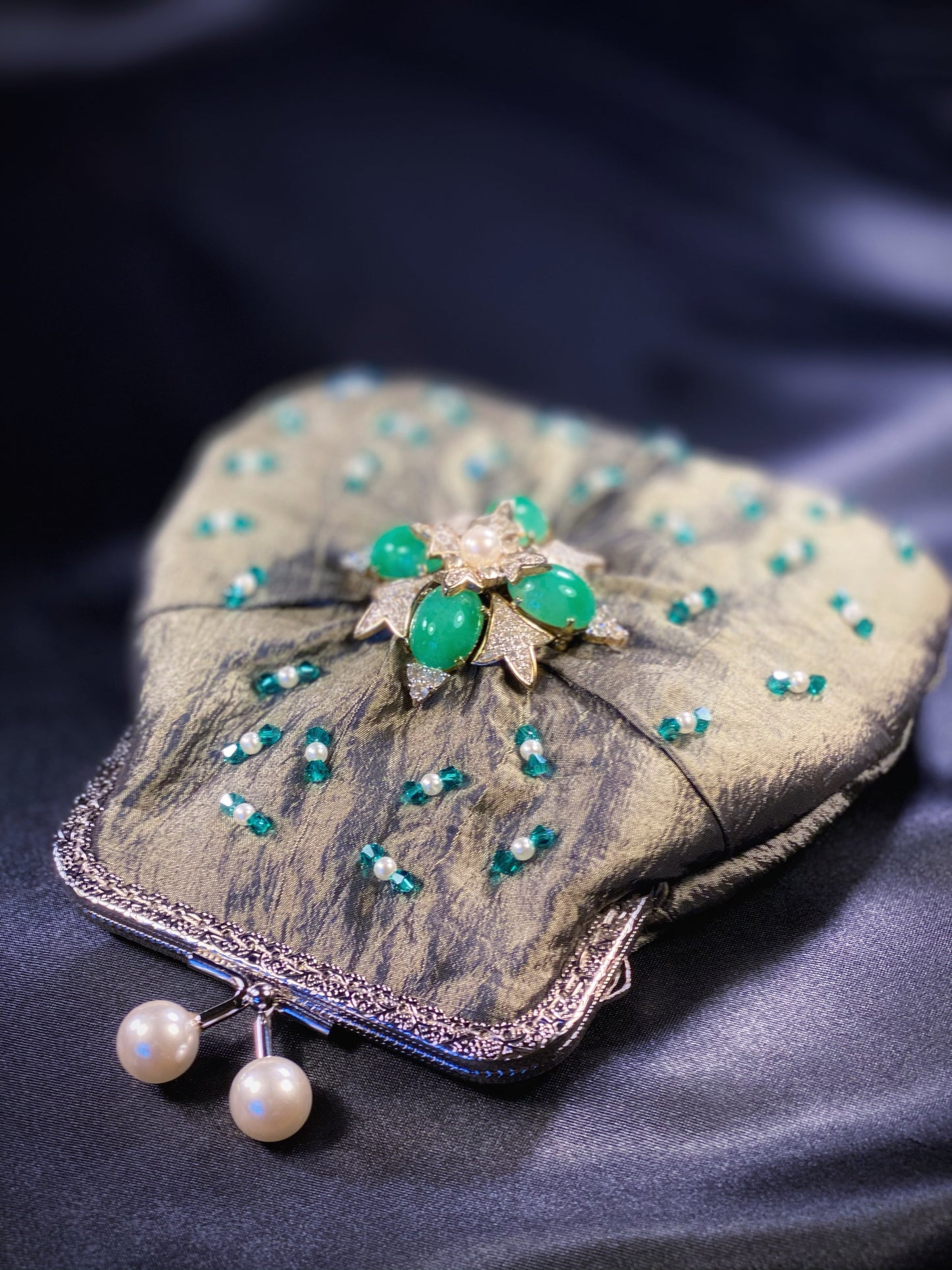 Meet Fern. A green, silk wristlet purse with faux pearl clasp and an antique green stone centrepiece.