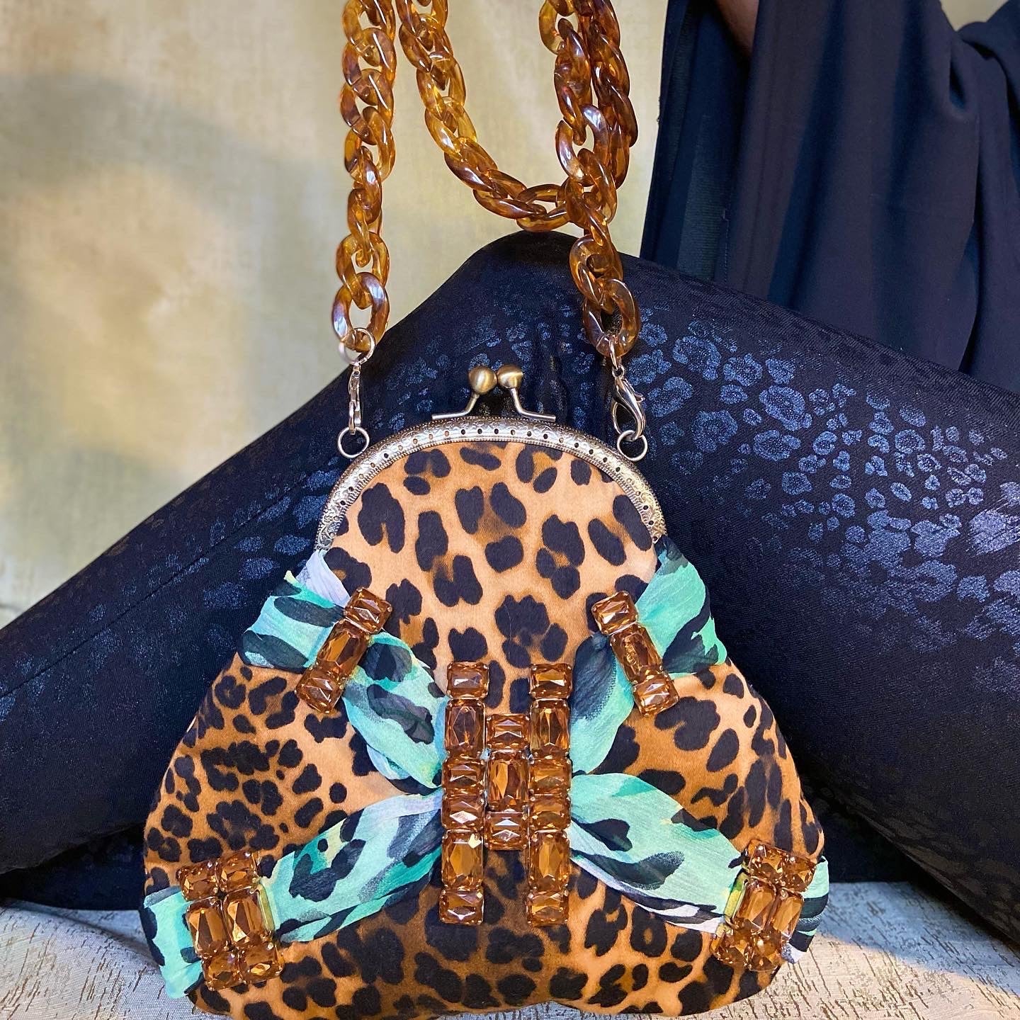 Meet Tabatha. A leopard print and green textile handbag with bronze rhinestones.
