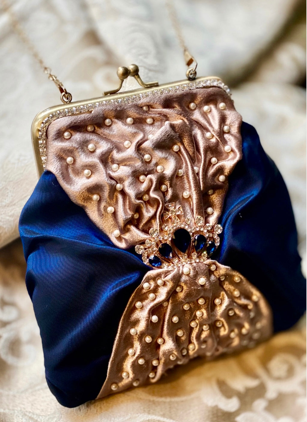 Meet Sandra, a small handbag with a crown centrepiece of blue and white diamonds.