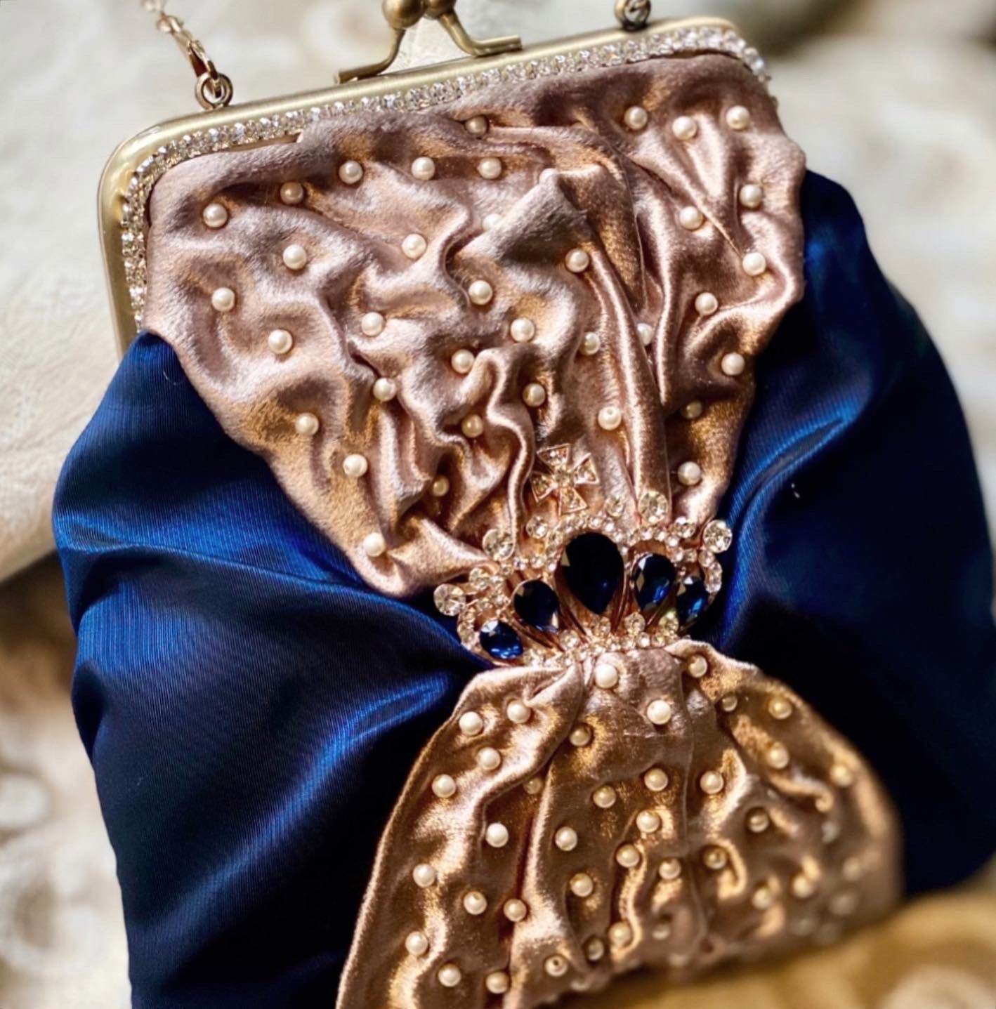 Meet Sandra, a small handbag with a crown centrepiece of blue and white diamonds.