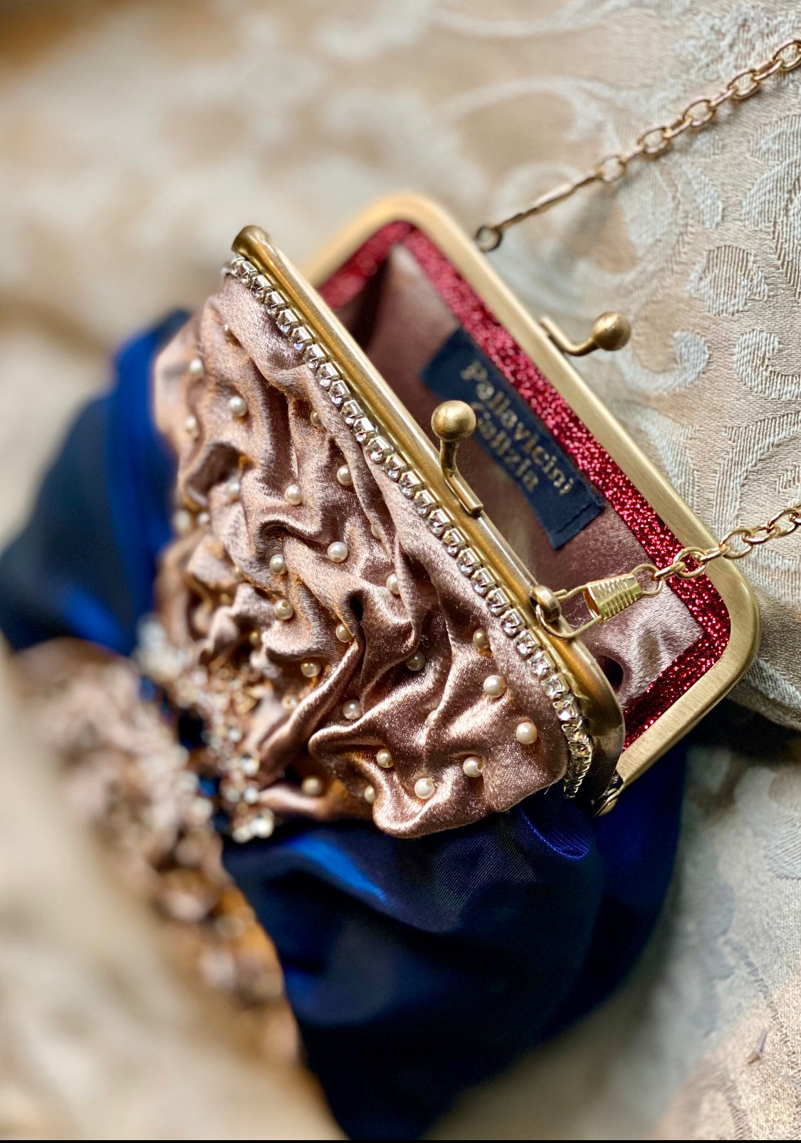Meet Sandra, a small handbag with a crown centrepiece of blue and white diamonds.