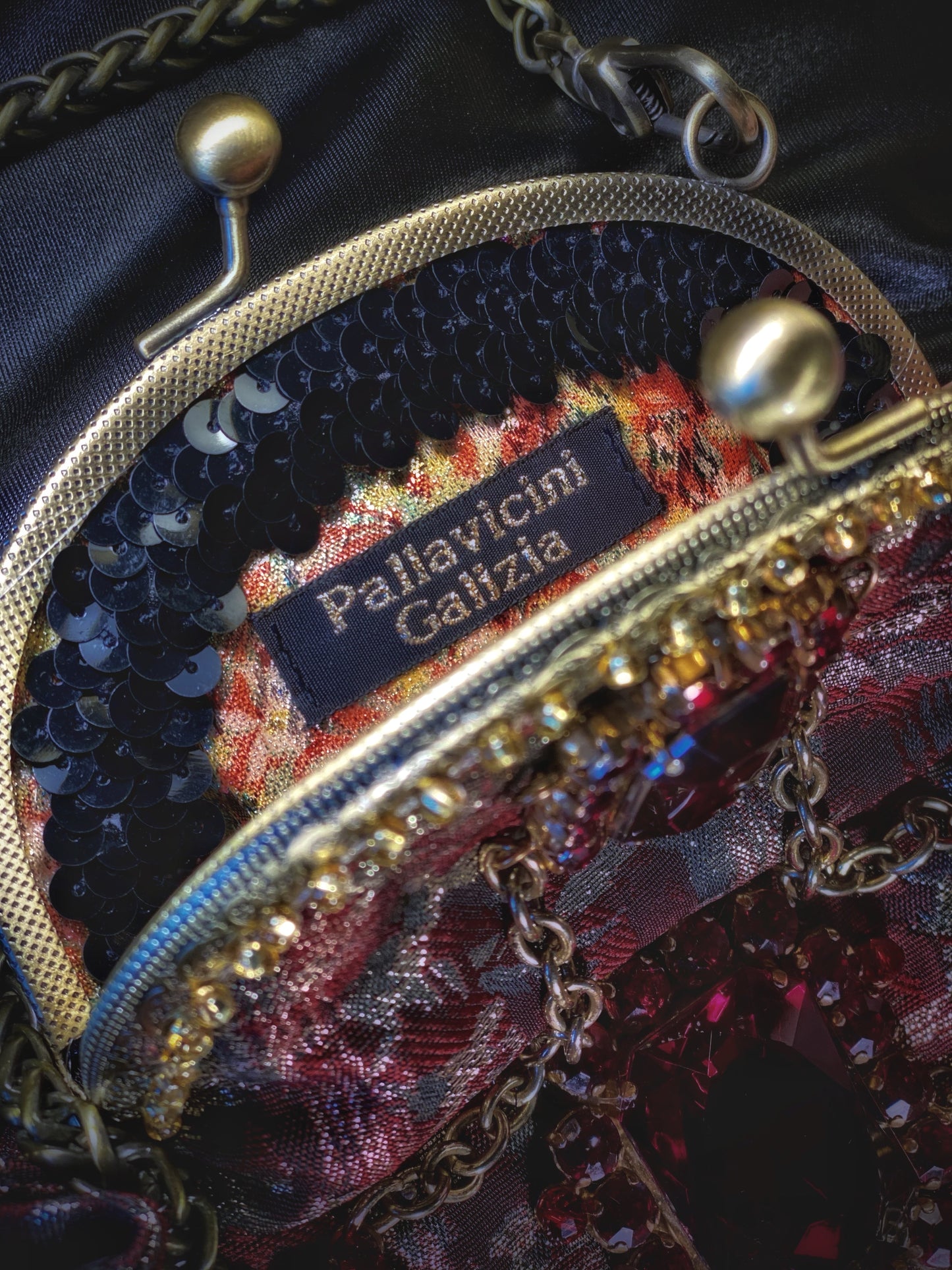 Meet Gapsy. A burgundy, gold & red shimmer handbag, adorned with super size red rhinestones and gold chain features.